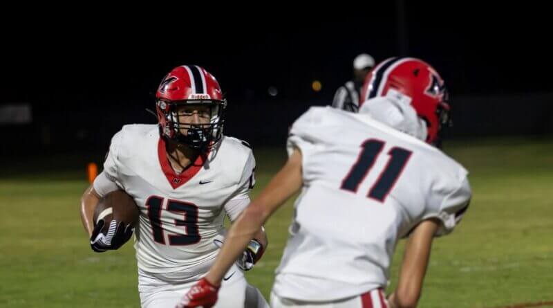 A Myrtle Hawks ball carrier turns upfield behind a teammate block during a Union County high school football game.